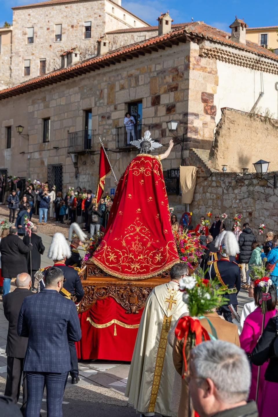 El manto rojo bordado del Resucitado visto desde atrás, camino del casco histórico