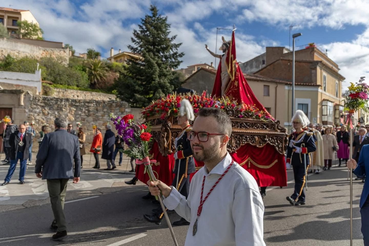 Hermano con flores acompañando el cortejo del Resucitado